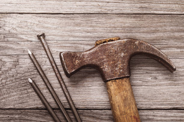 istock Hammer and nails on a wooden table, top view 1209233075