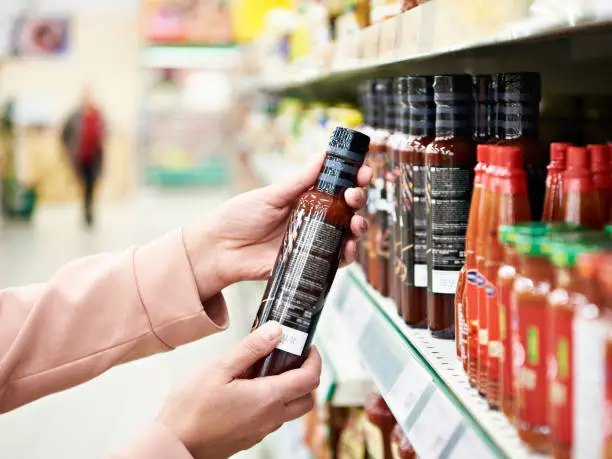 Photo of Culinary sauce in hand buyer at store