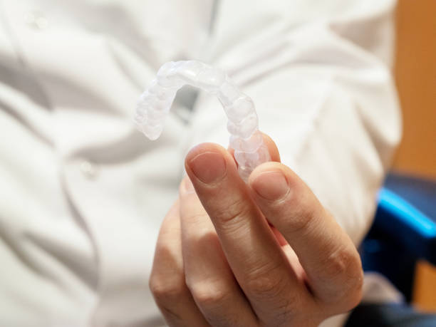 istock Dentist holding a silicone trainer, dental aligner 1209236704