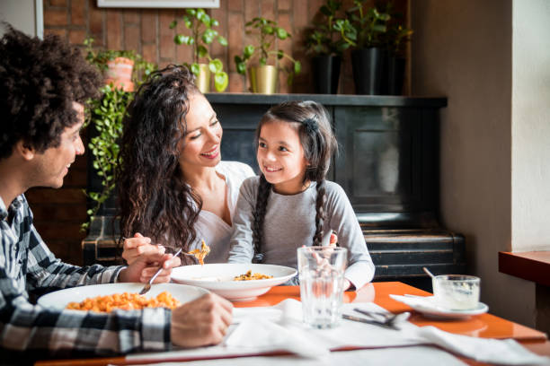 glückliche afrikanische amerikanische familie essen mittagessen zusammen im restaurant und spaß haben - kubaner stock-fotos und bilder