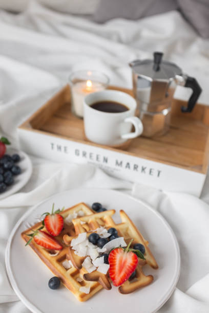 istock Beautiful breakfast in bed: Viennese Belgian waffles decorated with berries, a plate with strawberries and blueberries 1209237581