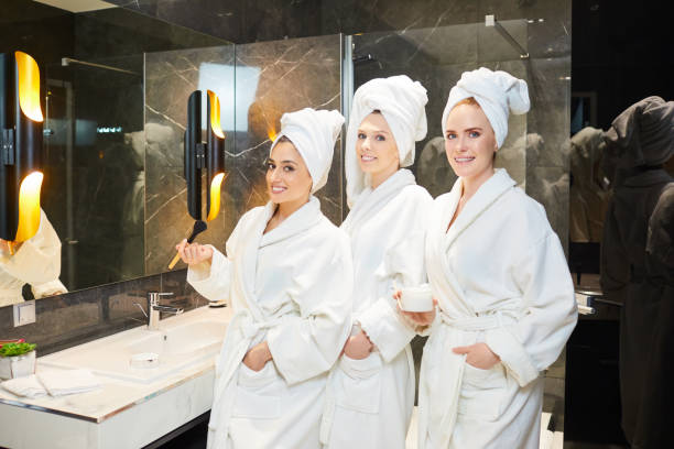istock Young women in white bathrobe at a spa party 1209238983