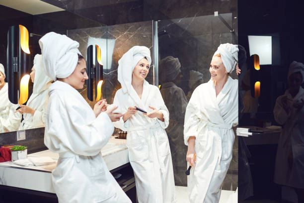 istock Young women in white bathrobe at a spa party 1209238990