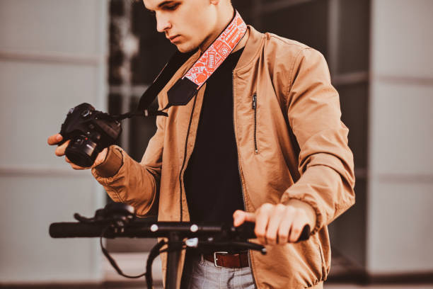 istock Man with scooter and proto camera is watching photos 1209241520