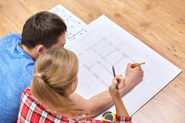 istock smiling couple looking at blueprint at home 1209245267