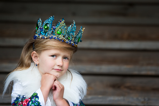 A sad little queen. Girl with a crown scarecrow