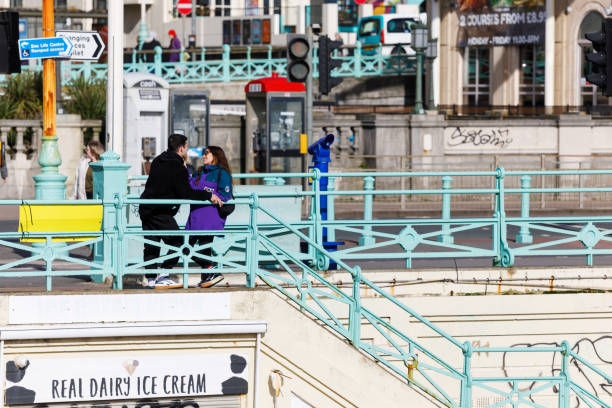 Brighton, England - February 26, 2020: Romantic young couple standing on Brighton pier.