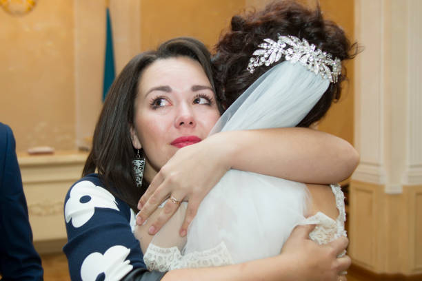 Parents kiss their smiling daughter on her wedding day.