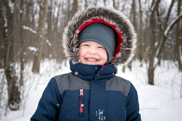 istock Little Boy Smiling Outdoors during Winter Storm. 1209249341