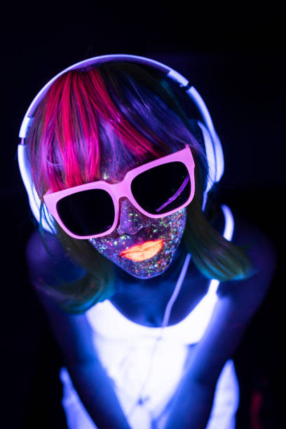 istock Woman painted in neon makeup with sunglasses and fluorescent headset 1209250764