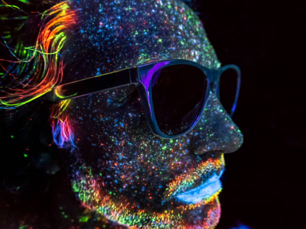 istock Man with sunglasses painted with fluorescent make up 1209250767