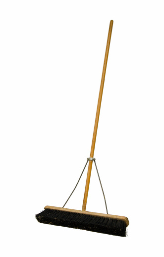 A large used push broom as used on walkways, garages,sidewalks, shops, and industrial areas. On a transparent background with a clipping path.