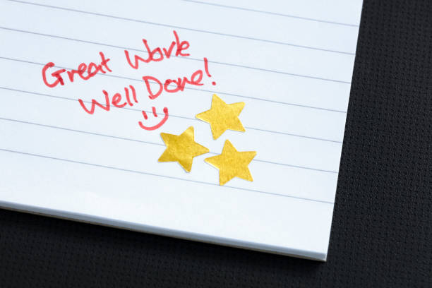 Gold star award, great work, well done Excellent work gold star award on notepad homework paper stock pictures, royalty-free photos & images