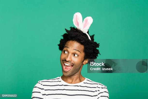 Green Portrait Of Excited Young Man With Rabbit Ears Headband Stock Photo - Download Image Now