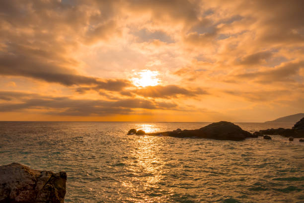 istock Sea Dawn and Golden Clouds on the Rocky Shore 1209256263