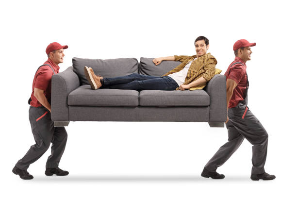 istock Movers carrying a sofa and a casual guy sitting on the sofa 1209258586