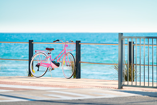 Pink classic bicycle parked near beach in Australia