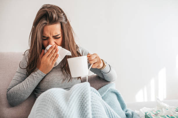 istock Sick woman blowing her nose 1209260043