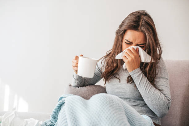 istock Sick woman blowing her nose 1209261492