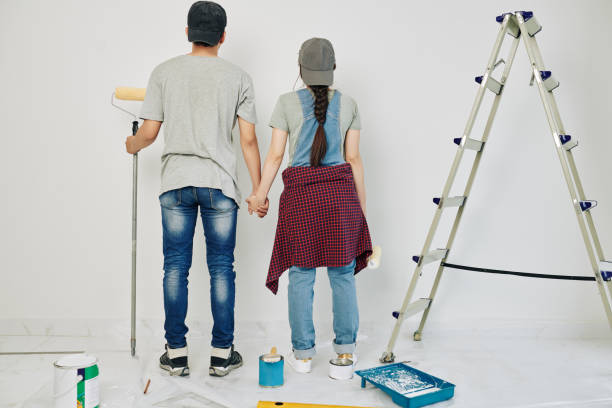 istock Couple painting walls together 1209264110
