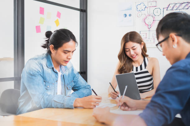 istock Young Asian people writing on book for working and studying concept 1209264263