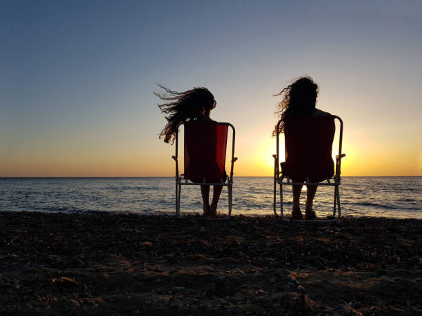 Free Stock Photo of Two Women Sitting on the Beach Watching the Sunset ...