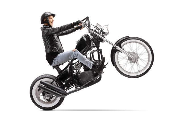 istock Young biker riding a custom motorbike on one wheel 1209265196