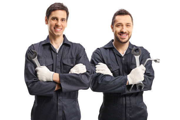 istock Two male workers in uniforms holding tools and looking at the camera 1209265219