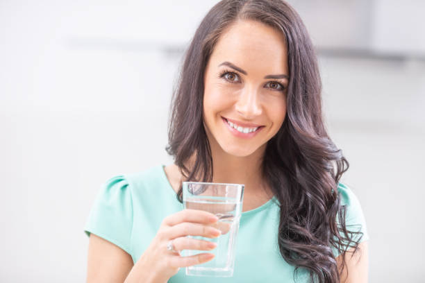 istock young woman drinks clean water adheres to drinking regime. 1209267720