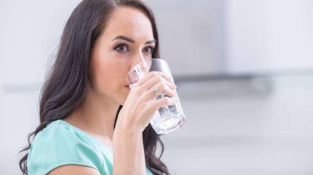 istock young woman drinks clean water adheres to drinking regime. 1209267722