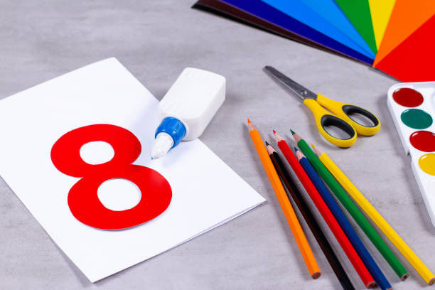 istock Sheets of paper, glue and scissors on a table. March 8 from paper 1209272408