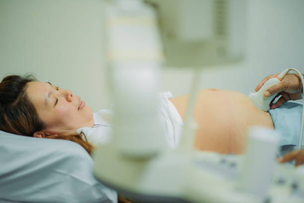 asiatische chinesische schwangerschaft frau liegt auf dem bett, während arzt ultraschall-scanning im krankenhaus - bed hospital prognosis patient stock-fotos und bilder