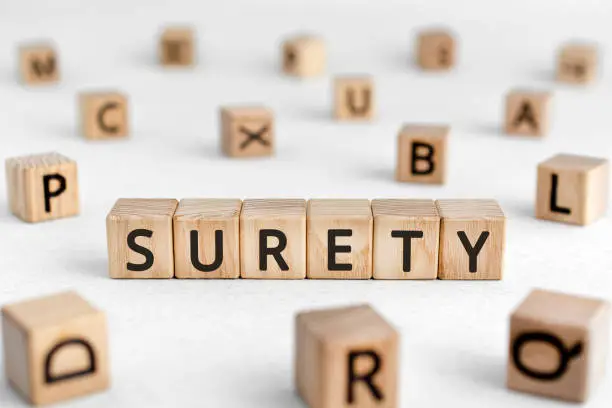 Surety - words from wooden blocks with letters, a person who takes responsibility for another's surety concept, white background