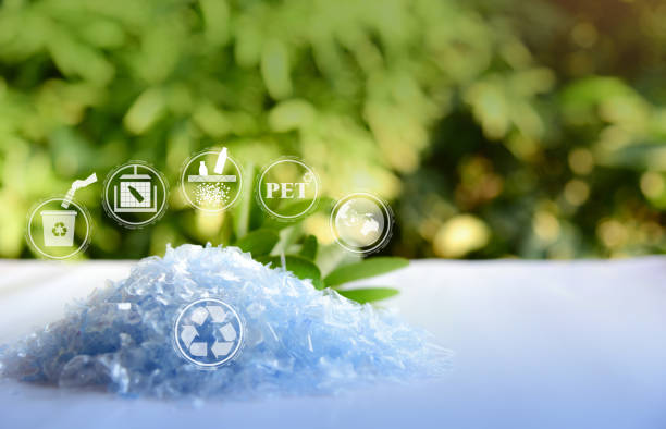A Pile of PET bottle flakes with green tree blur background. A Pile of PET bottle flakes with green tree blur background.Recycle icon,picking up Plastic Bottle,PET icon&Compress bale icon.Save environment concept polyester photos stock pictures, royalty-free photos & images