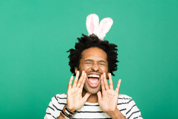istock Spring portrait of funky young man with rabbit ears headband 1209276756