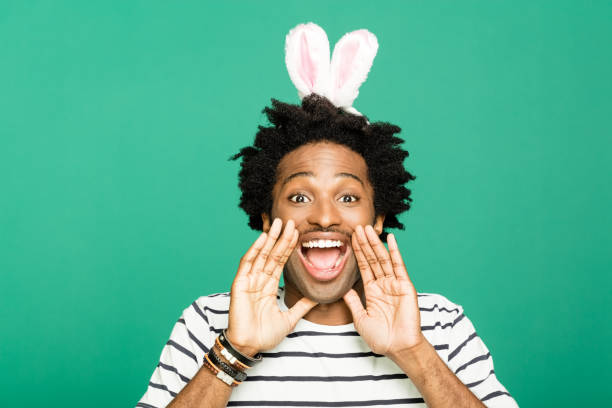 istock Spring portrait of funky young man with rabbit ears headband 1209276866