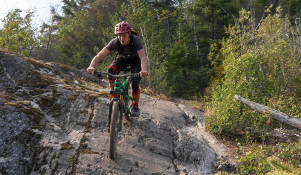 Mountain biker descends steep rock slab