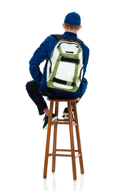 istock Young male high school student resting in front of white background wearing backpack and holding bag 1209279878