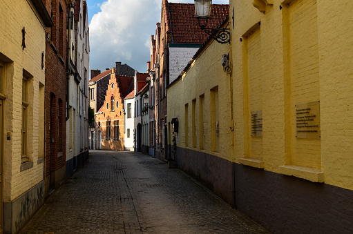 Bruges, Belgium. August 2019. In the small secondary streets of the center the late afternoon sun illuminates the brick facades of the typical houses. Nobody.
