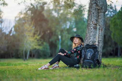 blonde beautiful woman sitting under tree