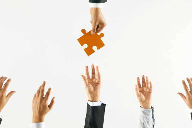 istock Hand Giving Orange Jigsaw Puzzle Piece 1209282723