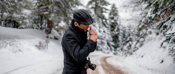 istock Photographer with coat and flat tweet hat smoking 1209283582