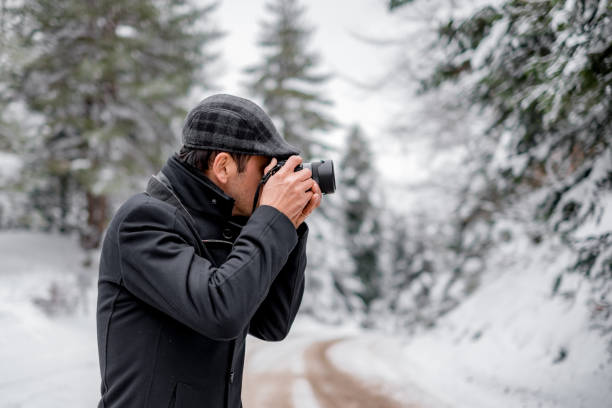 istock Photographer in snowy woods 1209284050