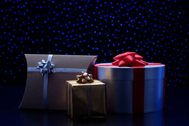 istock Three elegant gift boxes with ribbon against blue illumination background 120928763
