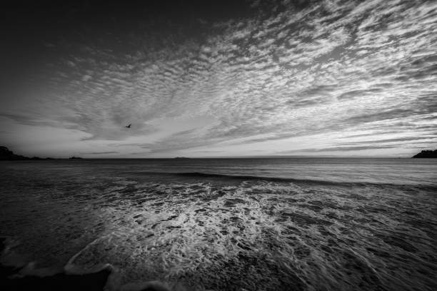 patrones opuestos de nubes en el cielo y lavado de ondas en la arena. - backwash fotografías e imágenes de stock