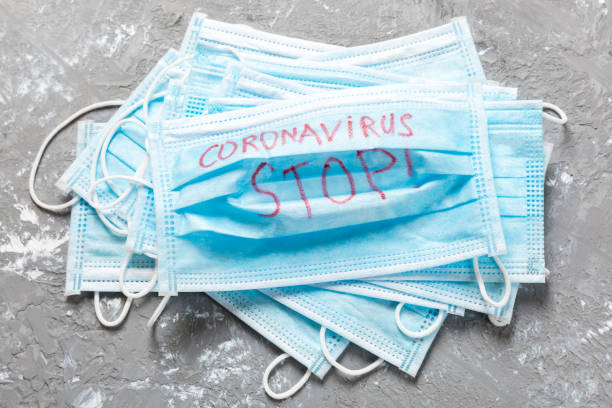 istock coronavirus stop word written on medical mask. Coronavirus stop text on protective mask for your desing, Wuhan , 2019-nCoV. concept top view 1209290511
