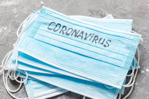 istock coronavirus word written on medical mask. Coronavirus text on protective mask for your desing, Wuhan , 2019-nCoV. concept top view 1209290545