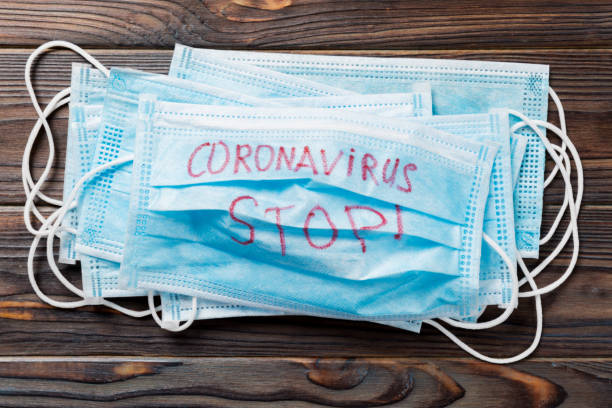 istock coronavirus stop word written on medical mask. Coronavirus stop text on protective mask for your desing, Wuhan , 2019-nCoV. concept top view 1209290567