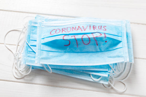 istock coronavirus stop word written on medical mask. Coronavirus stop text on protective mask for your desing, Wuhan , 2019-nCoV. concept top view 1209290695