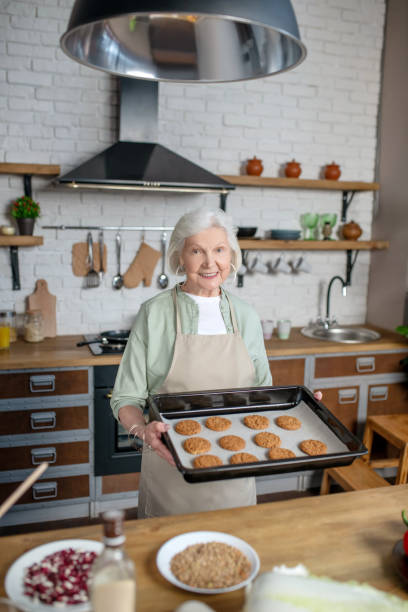istock Elderly woman cooking pastry in her kitchen 1209299482